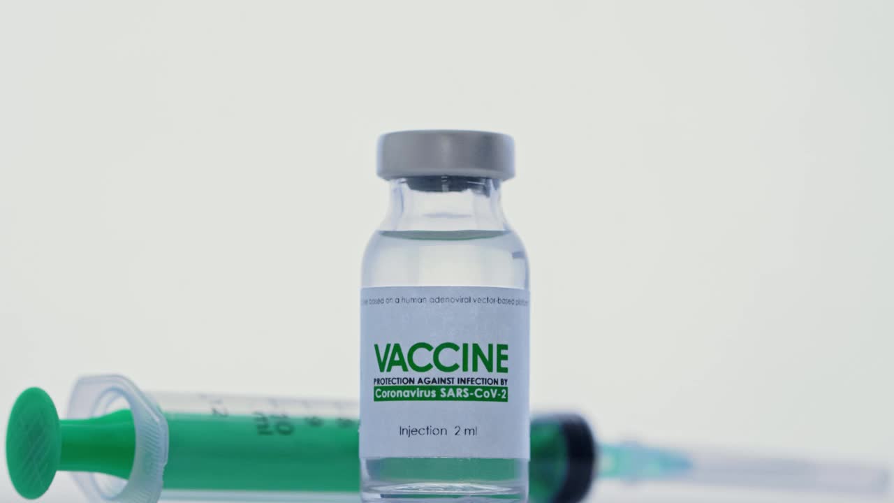 研究实验室，医生从治疗COVID-19冠状病毒疫苗瓶中取出注射器注射。大流行疫苗接种的概念。宏，交防护医用手套。瓶子在前景中视频素材