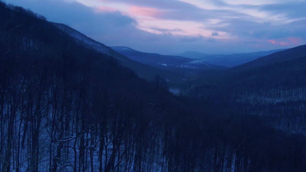 无人机拍摄的日落时分白雪覆盖的山谷视频素材