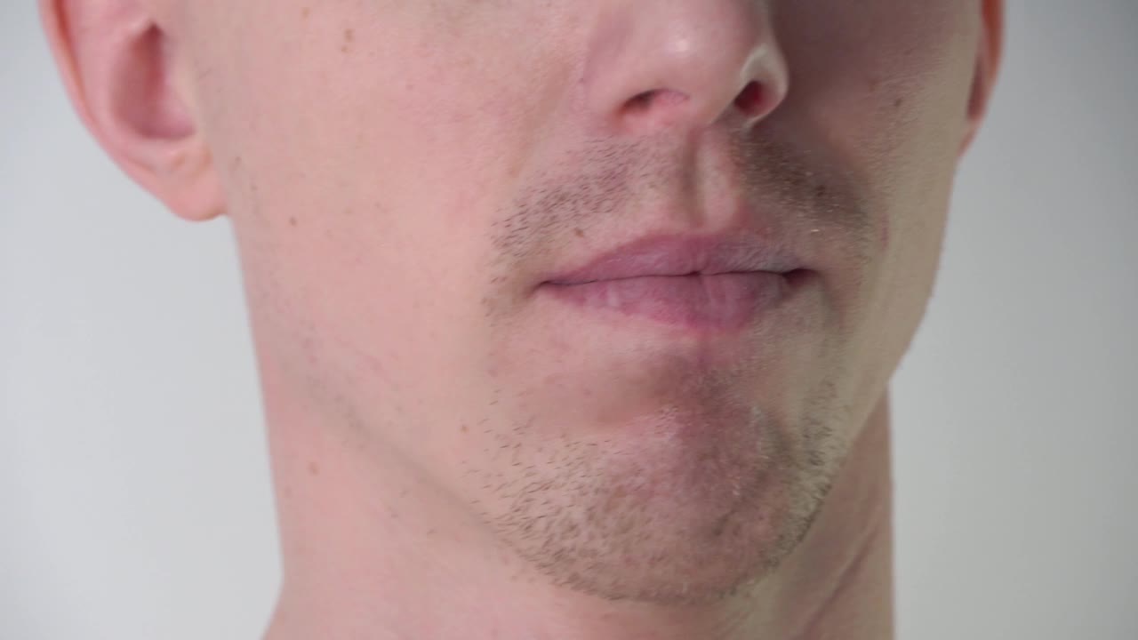 在浴室里，一个年轻男子在使用泡沫或剃须凝胶之前，用手抚摸自己的脸和胡茬。面部皮肤护理、剃须、胡茬、小胡子和络腮胡。不剃须的人视频素材