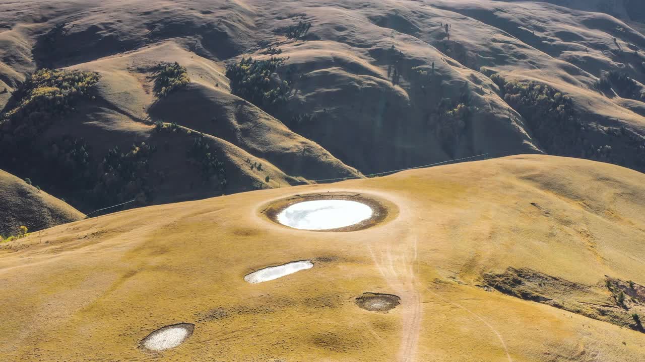 一个圆形的湖镶嵌在高山草甸上视频素材