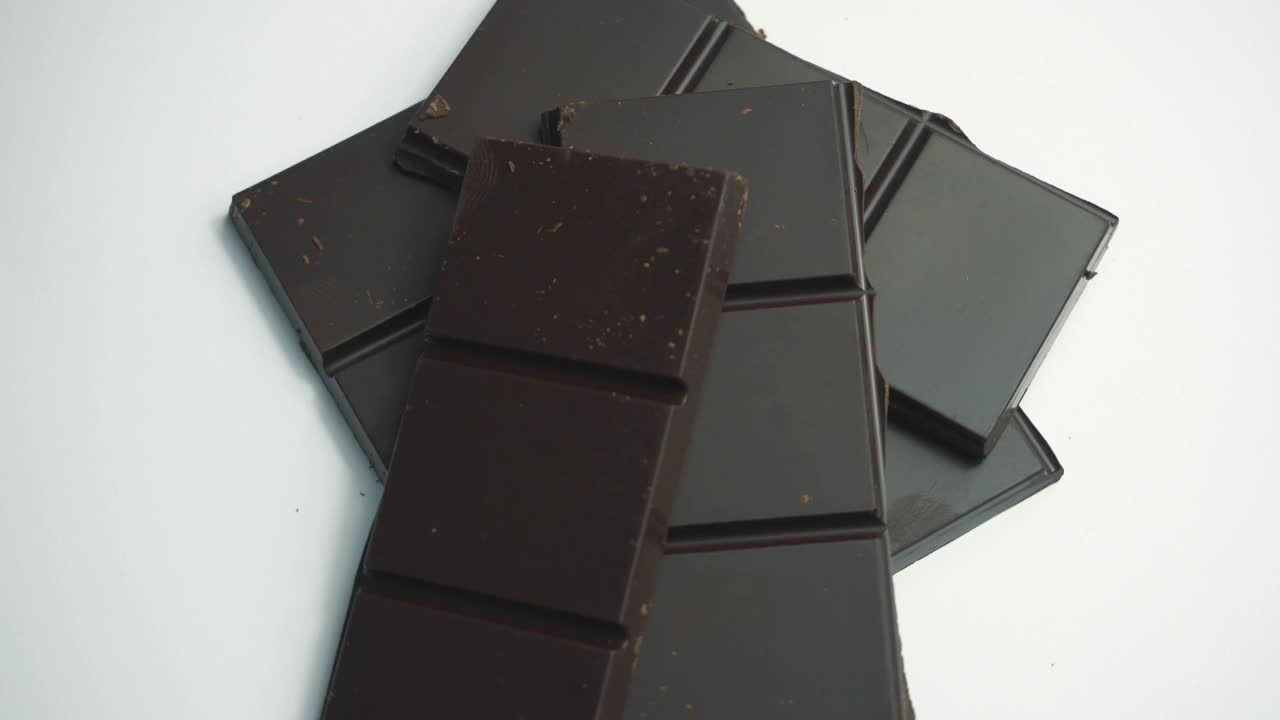 旋转视频的黑巧克力在白色的背景。视频下载