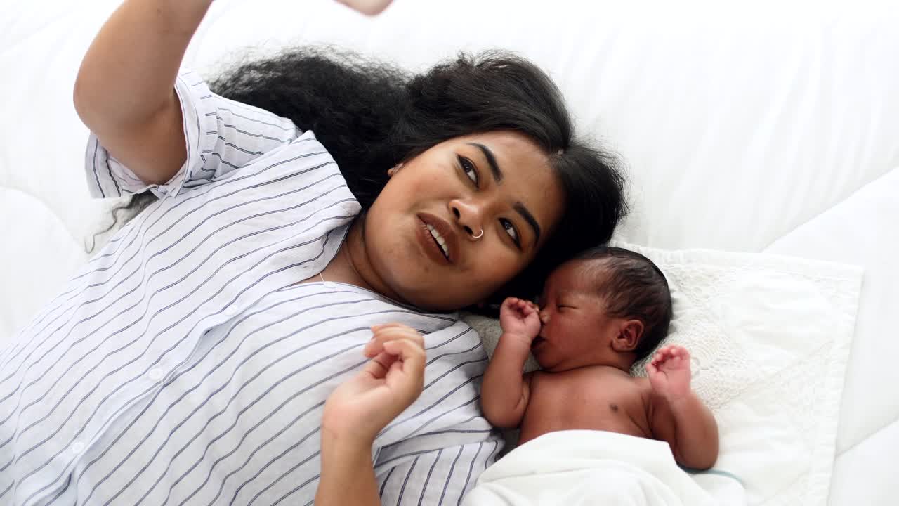妈妈和刚出生的男婴用智能手机自拍视频素材
