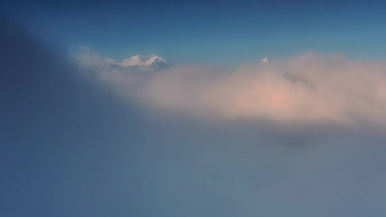 日出时，云海在雪山前翻滚，显得格外壮观视频素材
