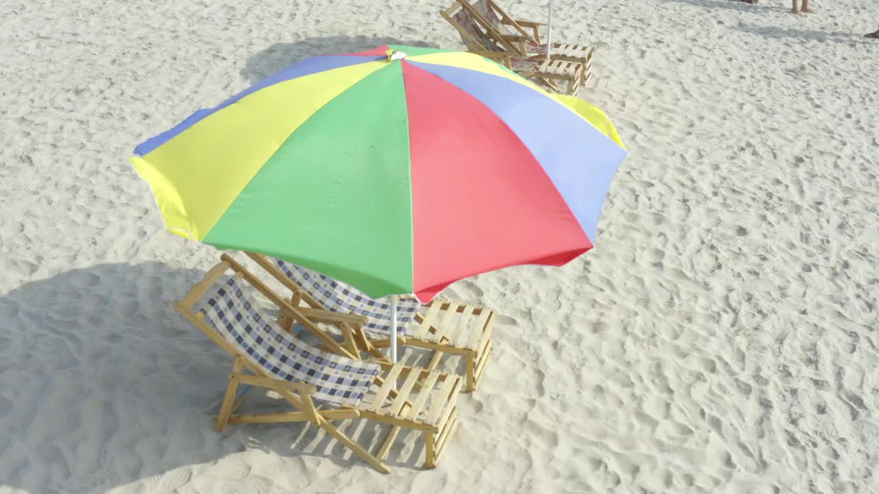 在热带海滩上的豪华座位上放置着色彩鲜艳的雨伞视频下载