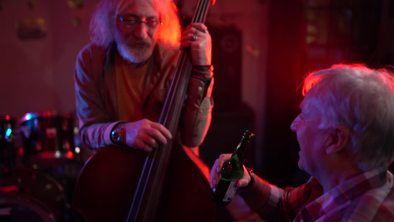 低音提琴手和他的朋友在夜店演出后聊天视频素材