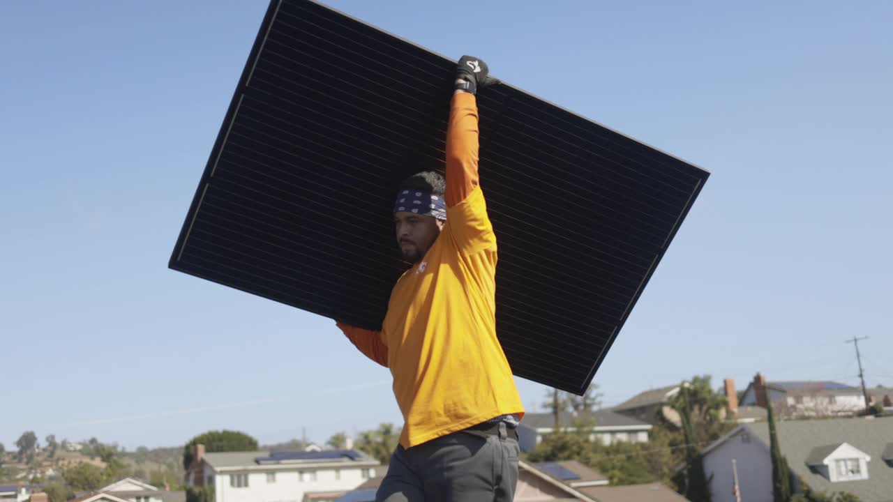 在加利福尼亚的住宅屋顶安装太阳能电池板的工人团队视频素材
