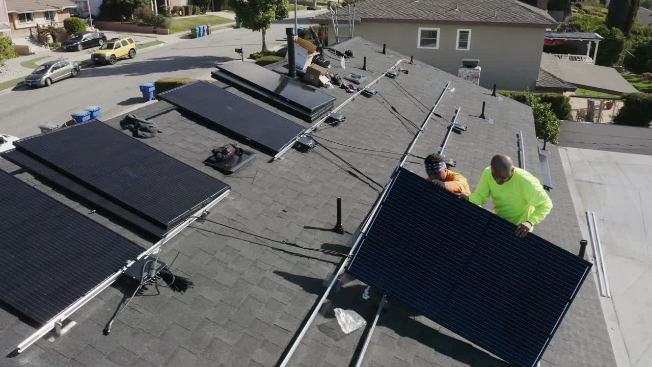 在加利福尼亚的住宅屋顶安装太阳能电池板的工人团队视频素材