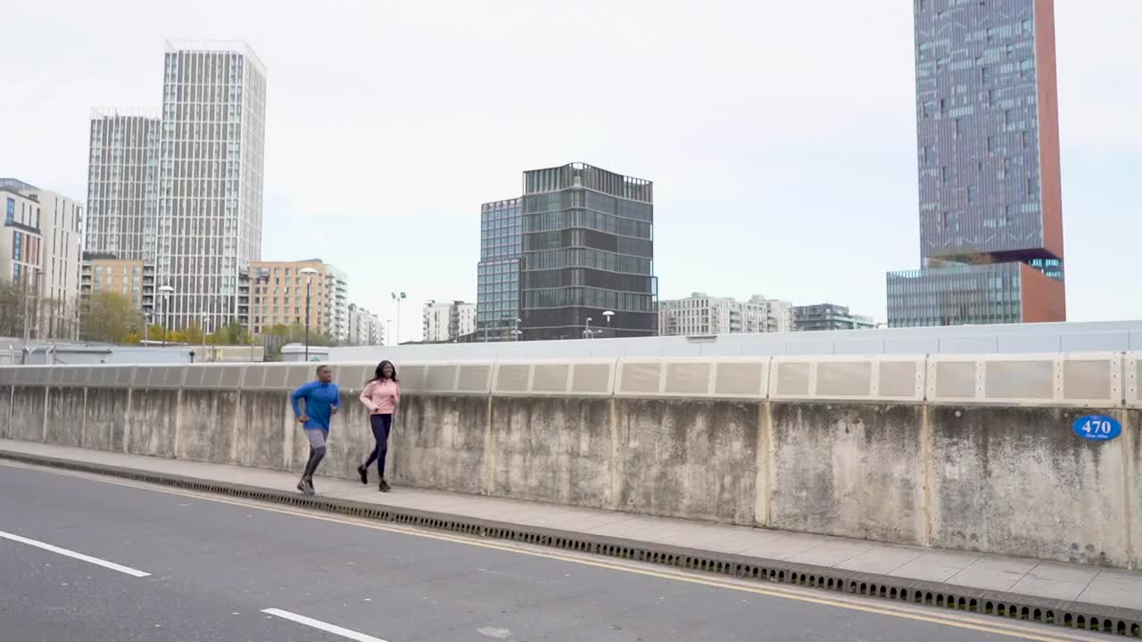 男性和女性健身朋友一起跑过一座桥视频下载