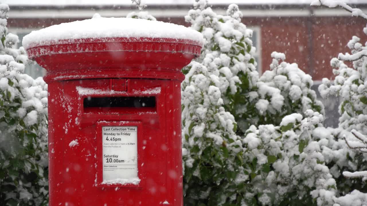 一个传统的红色信箱在飘落的雪的特写视频素材