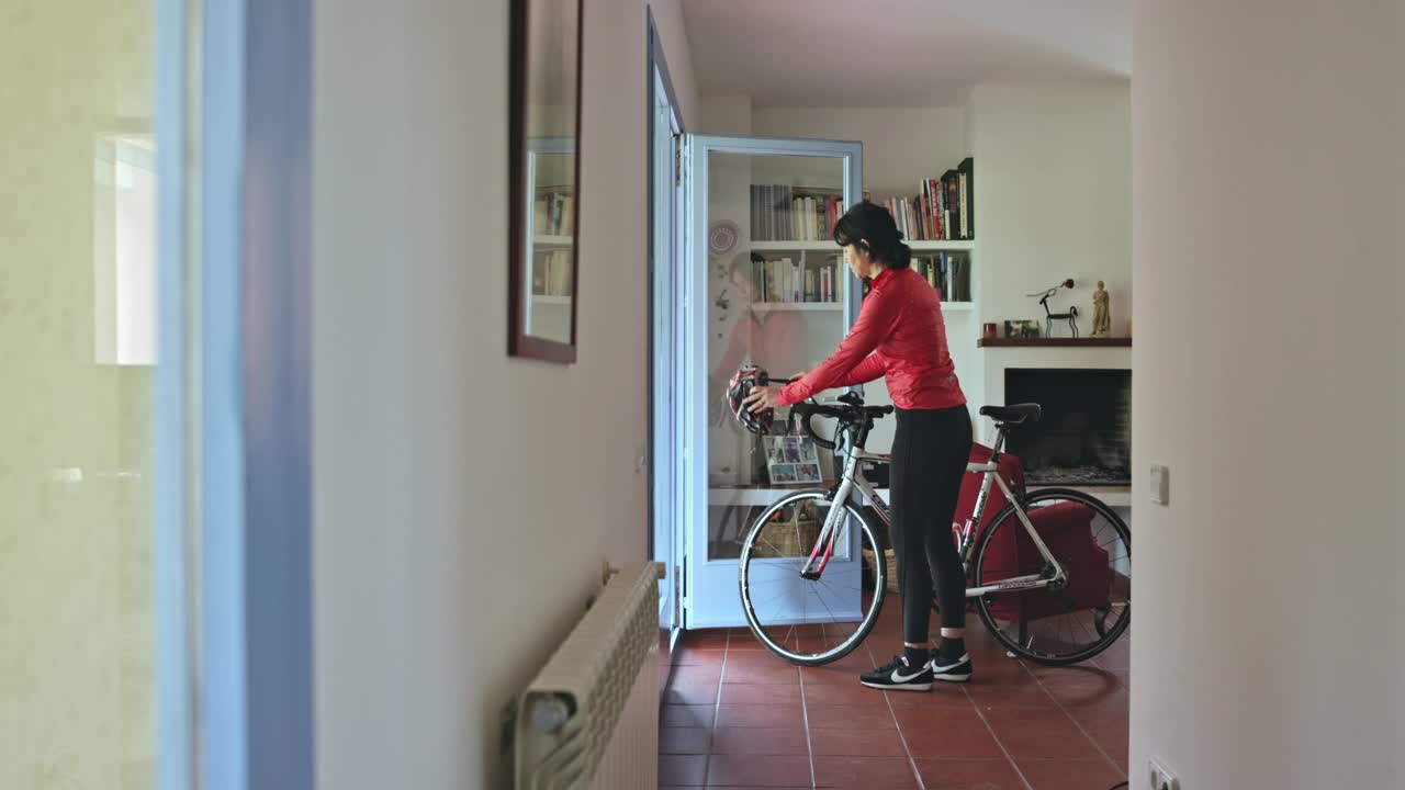 50岁早期女子铁人三项运动员离开家与赛车自行车视频素材