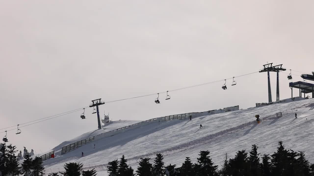 雪山滑雪坡道上的滑雪缆车和滑雪者视频素材