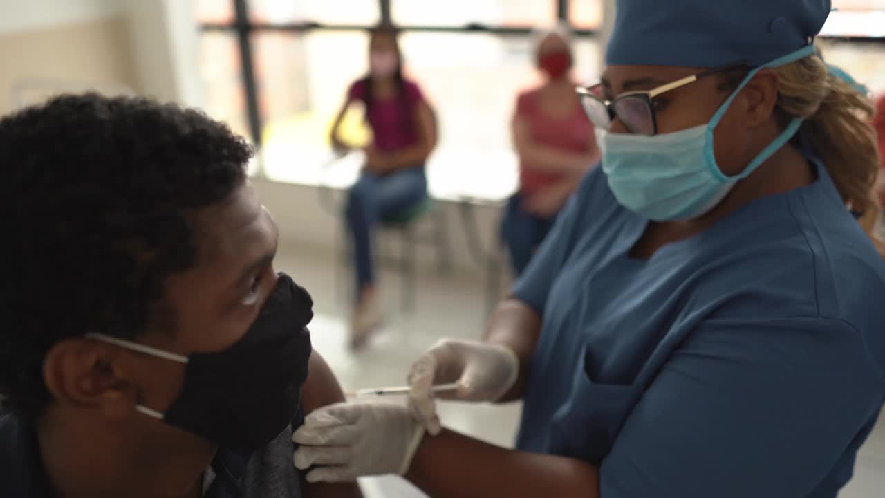 十几岁的男孩正在接种疫苗-戴着口罩视频素材