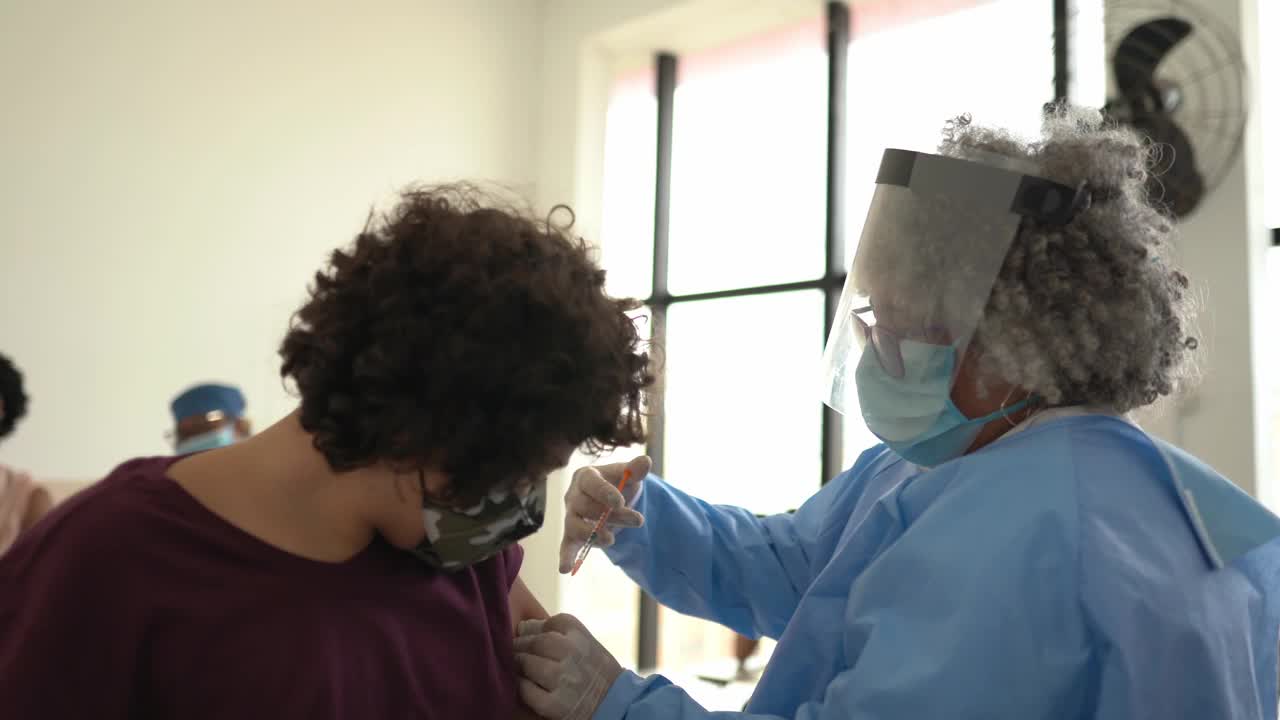 十几岁的男孩在接种疫苗后戴上口罩庆祝视频素材