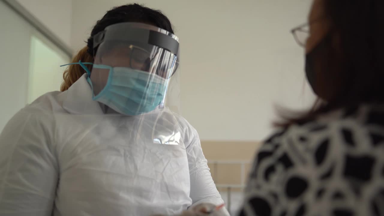 年长妇女戴着口罩接种疫苗视频素材