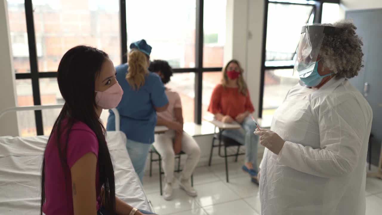 年轻妇女正在接种疫苗-戴口罩视频素材