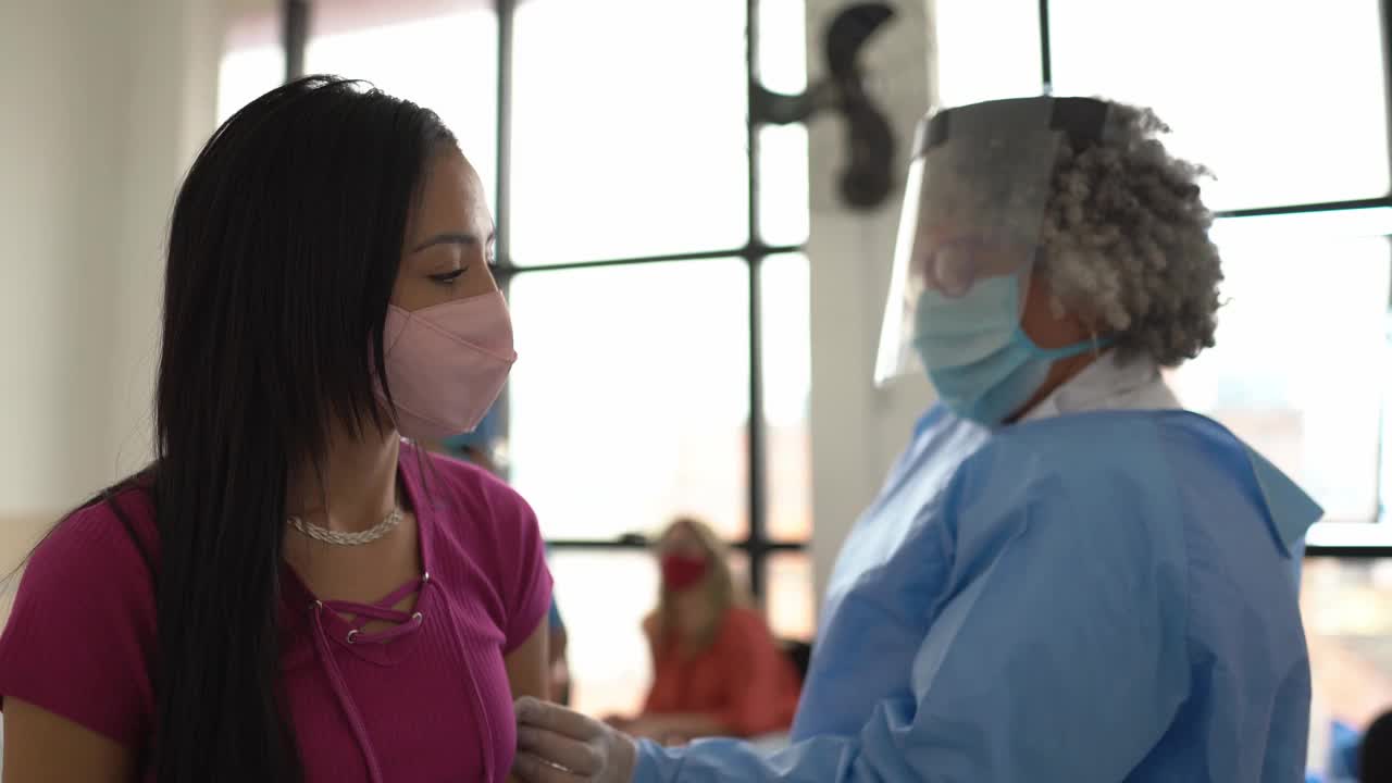 年轻妇女正在接种疫苗-戴口罩视频素材