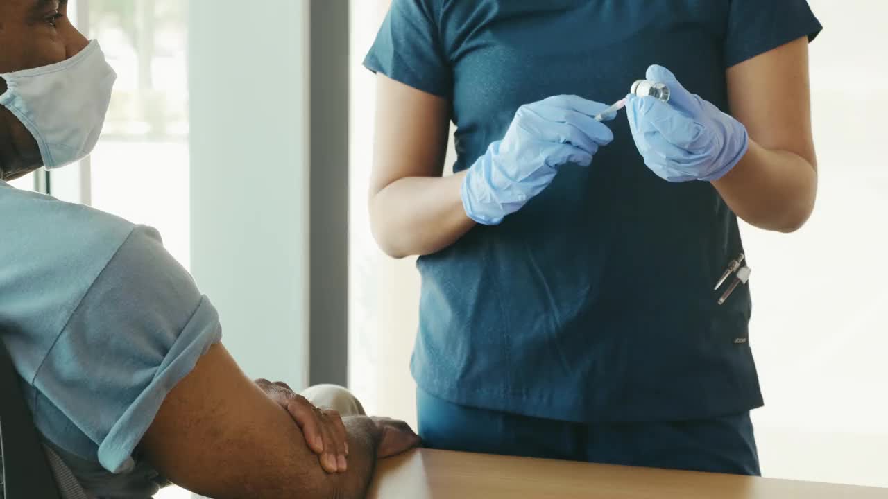 不认识的女护士为患者接种COVID-19疫苗视频素材