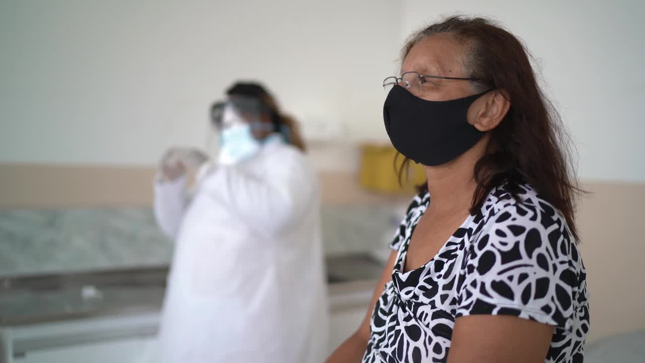 年长妇女戴着口罩接种疫苗视频素材