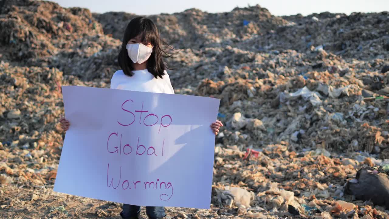 一个女孩正在为全球垃圾堆的未来而运动，回收，垃圾，塑料，环境，清洁，全球变暖，抗议，志愿者。视频素材
