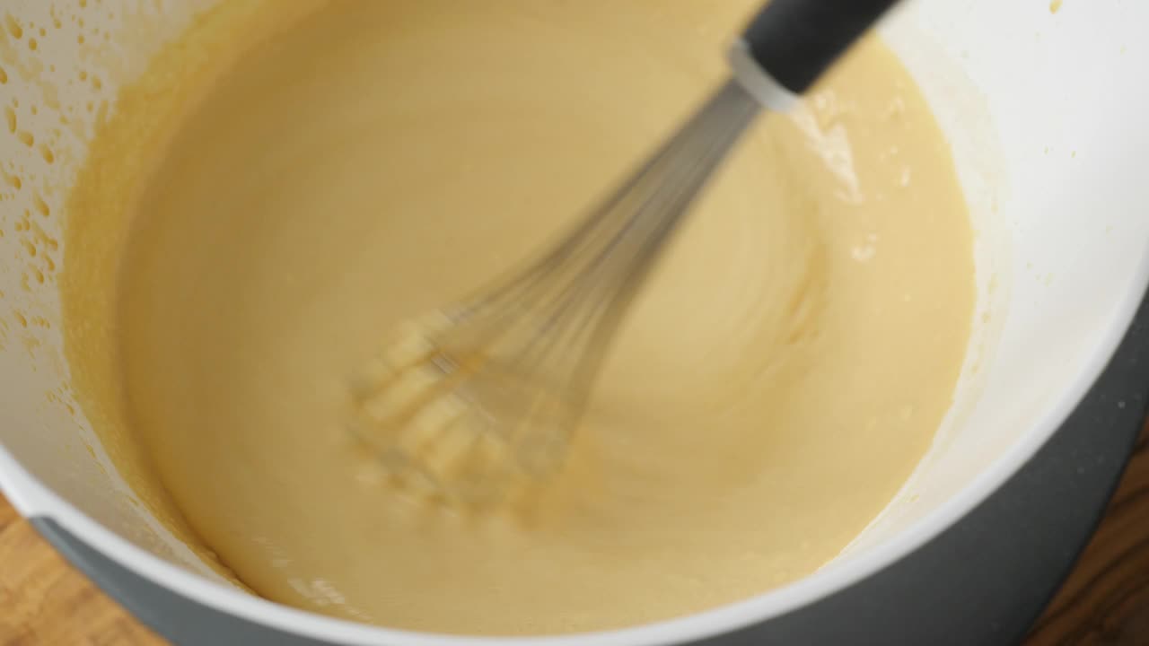 用手将鸡蛋、牛油、白糖、焦糖、奶油混合，制作布丁视频下载