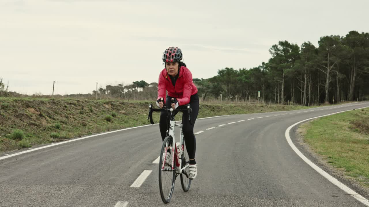 50岁出头的女铁人三项运动员在赛车自行车上锻炼视频素材