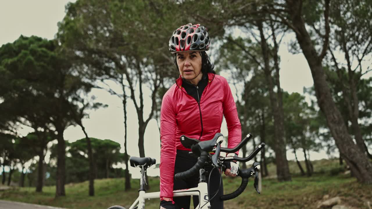 成熟的西班牙女性自行车运动员在锻炼期间休息视频素材