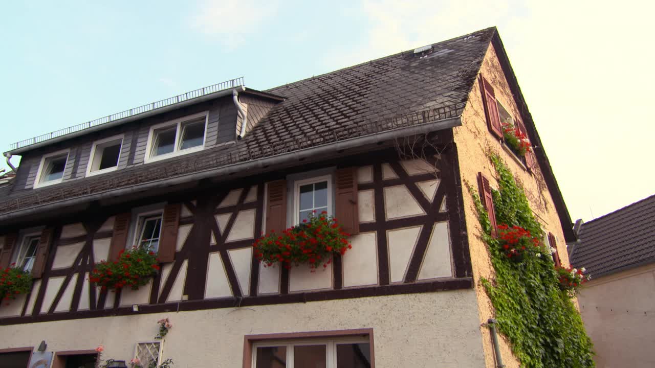 一个古色古色的德国村庄街道与历史建筑，一个教堂，鹅卵石，和一小群人骑自行车-莱茵河地区，德国视频下载