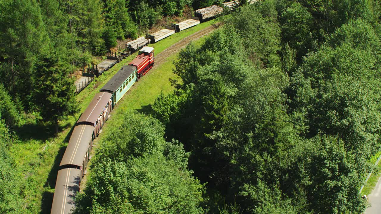 古老的旅游火车穿过Białowieża森林和周围的田野。鸟瞰图视频下载