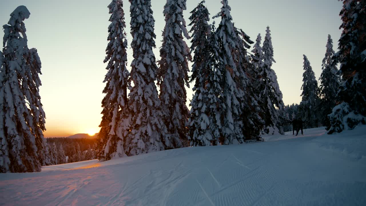 日落时分，两个人在跑道上越野滑雪视频素材