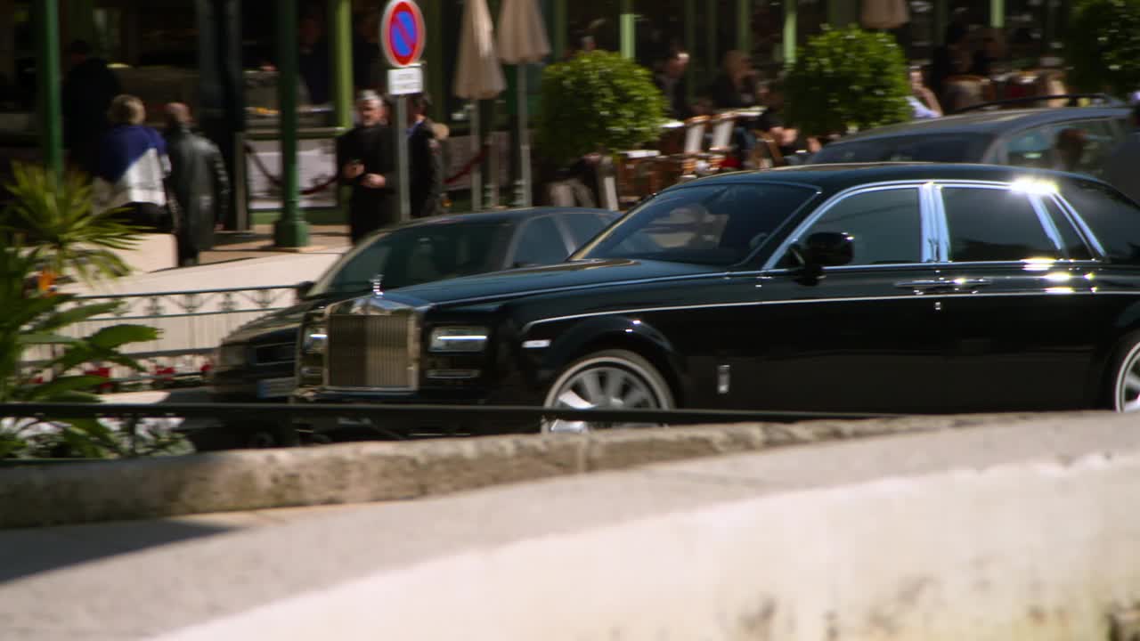 跟踪一辆豪华的劳斯莱斯汽车，因为它停在赌场，有明亮的阳光，人行道，和保安-蒙特卡洛，摩纳哥视频下载