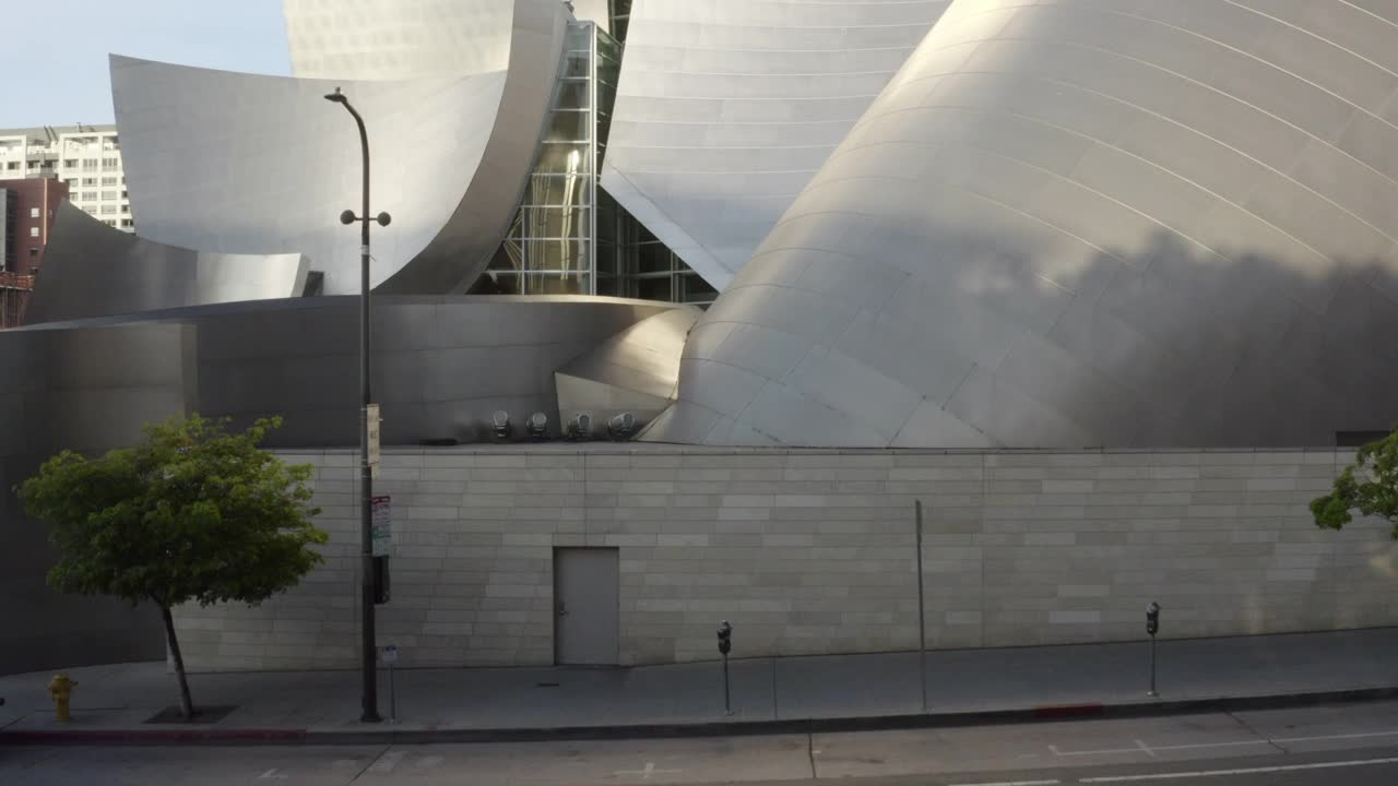 空中平移令人惊叹的现代建筑的华特迪士尼音乐厅在美丽的市中心La，蓝天和明亮的反射阳光-洛杉矶，加利福尼亚州视频下载