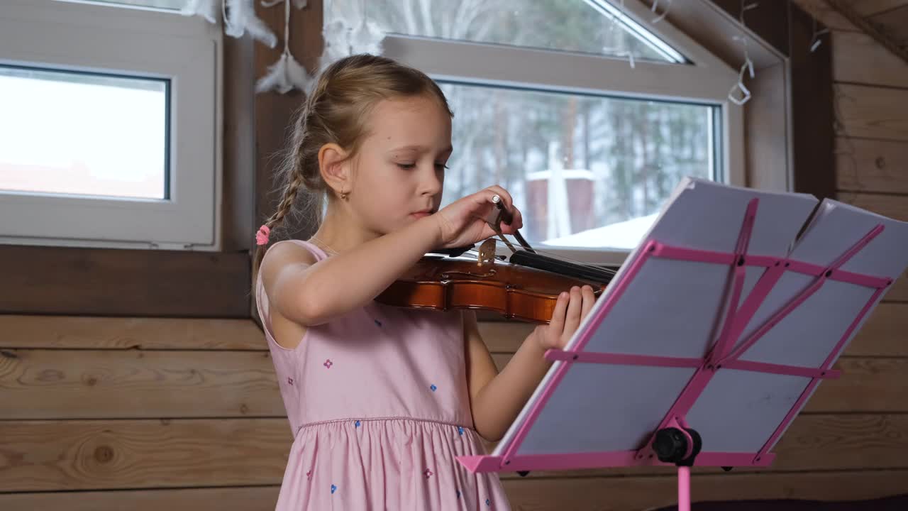 小女孩在家里拉小提琴和锻炼身体视频素材
