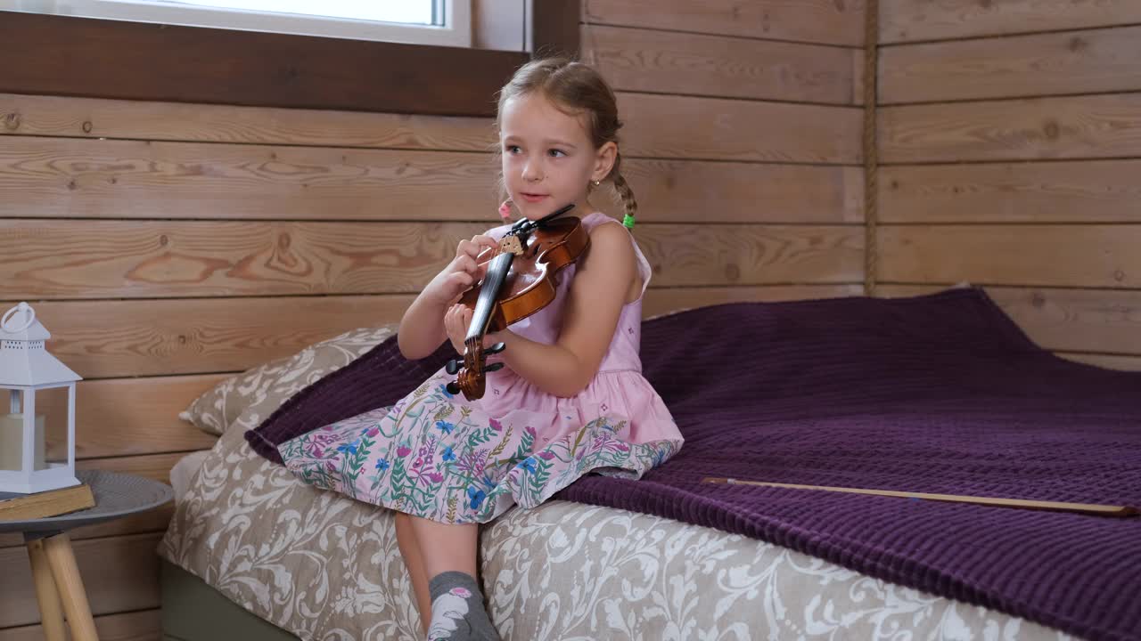 一个白人小女孩在家里拉小提琴视频素材