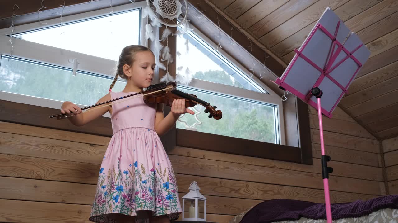 小女孩在阁楼学拉小提琴视频素材