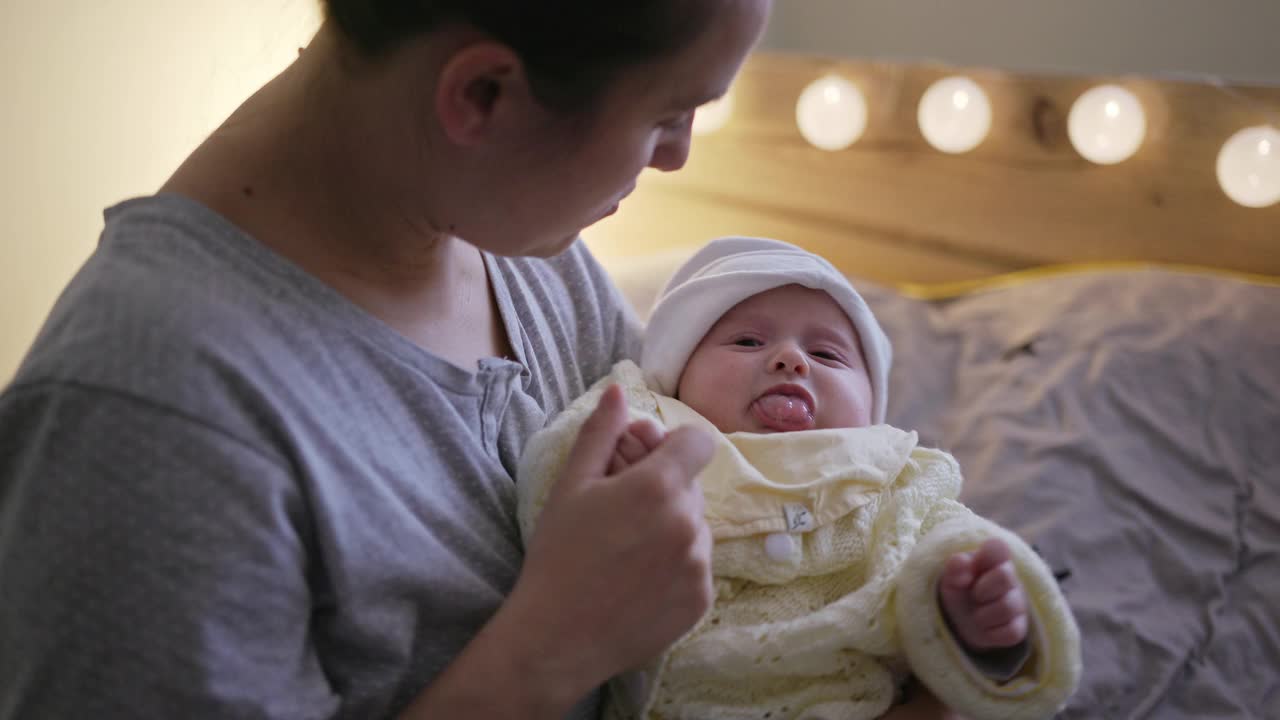 母亲在她的卧室里照顾她哭泣的新生儿。2019冠状病毒病大流行期间居家隔离。视频下载
