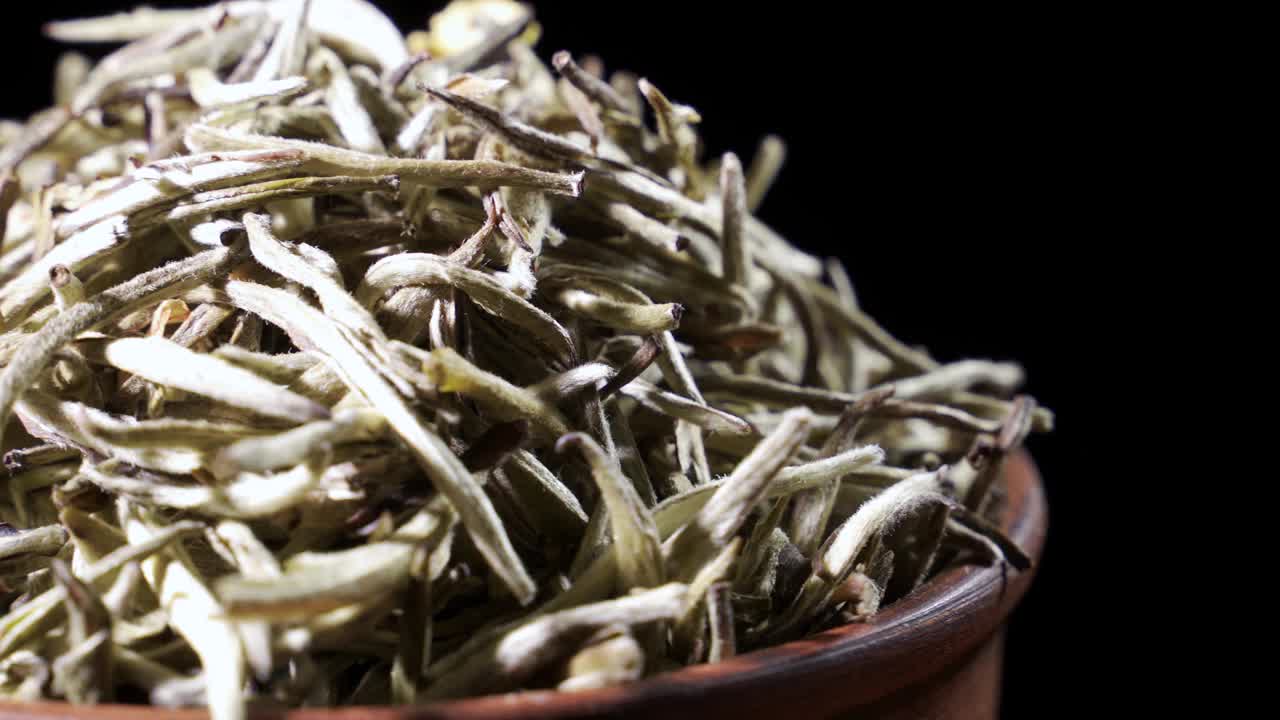 干茶叶在泥碗中旋转。概念-中国传统茶视频下载