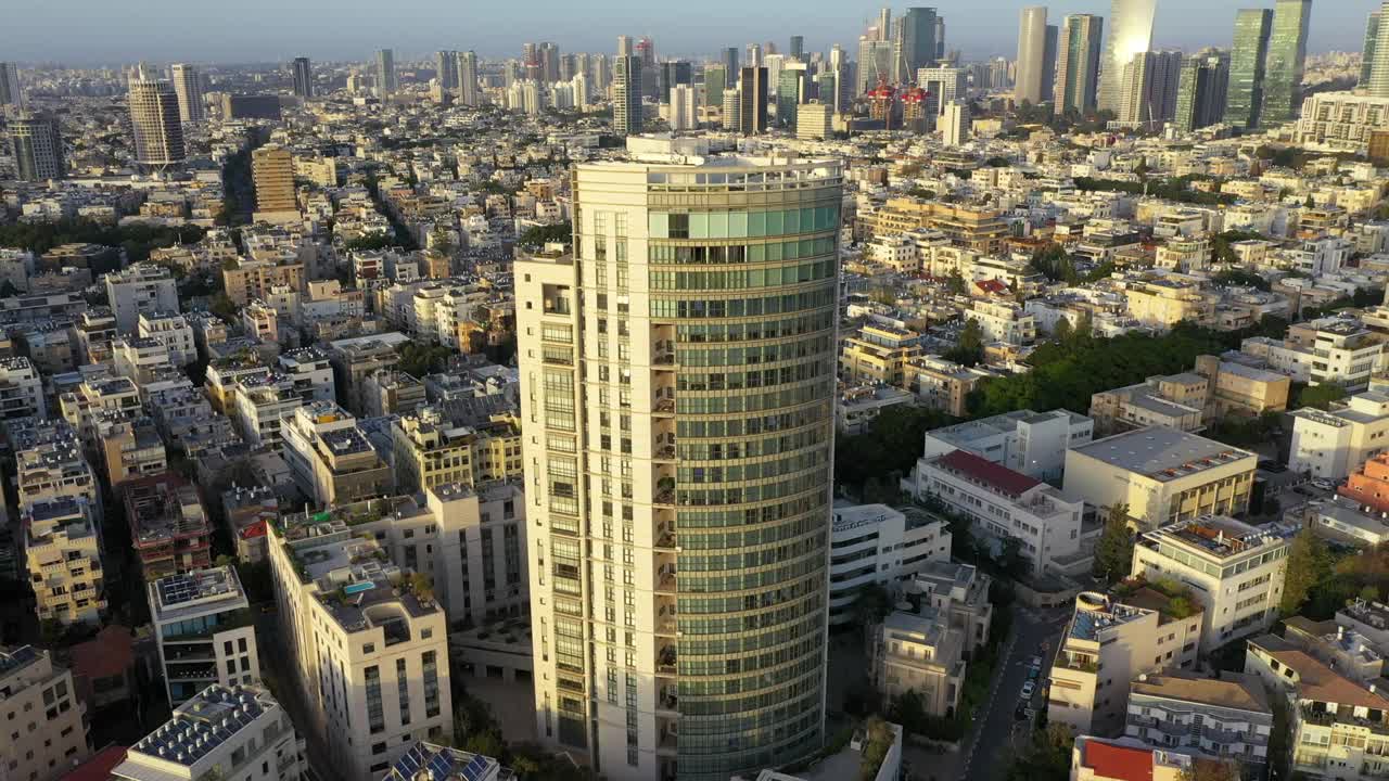 空中平移拍摄的现代公寓摩天大楼在城市日落，无人机飞在住宅楼在日落-特拉维夫，以色列视频素材