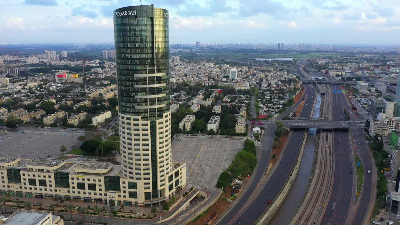 空中平移拍摄的现代办公大楼在城市高速公路上，无人机飞越城市景观在日落-特拉维夫，以色列视频素材