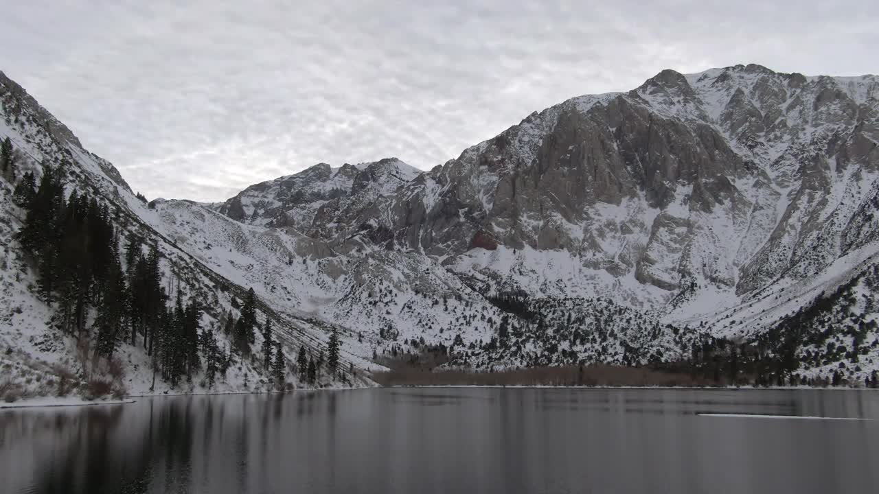 空中放大拍摄的雪山由定罪湖对天空，无人机飞过白色的风景在冬天-猛犸象湖，加利福尼亚视频素材