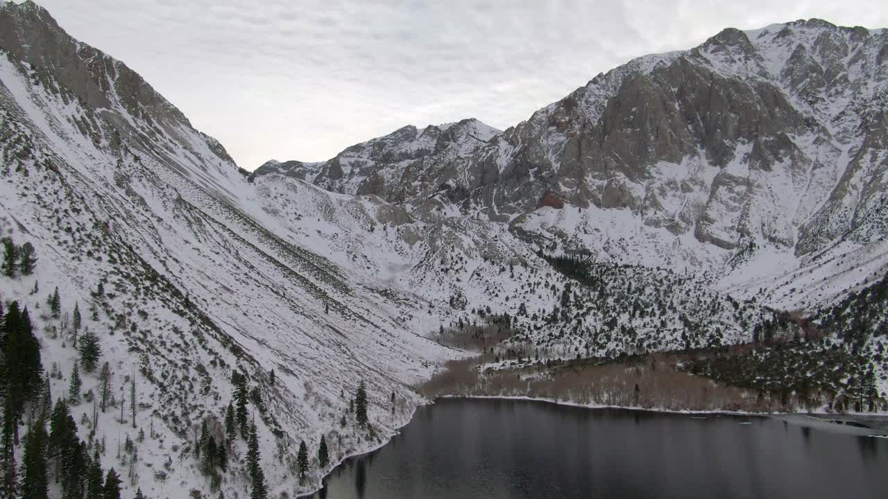 空中平移拍摄的积雪覆盖的山脉由定罪湖，无人机飞行在白色的景观在冬天-猛犸象湖，加利福尼亚视频素材