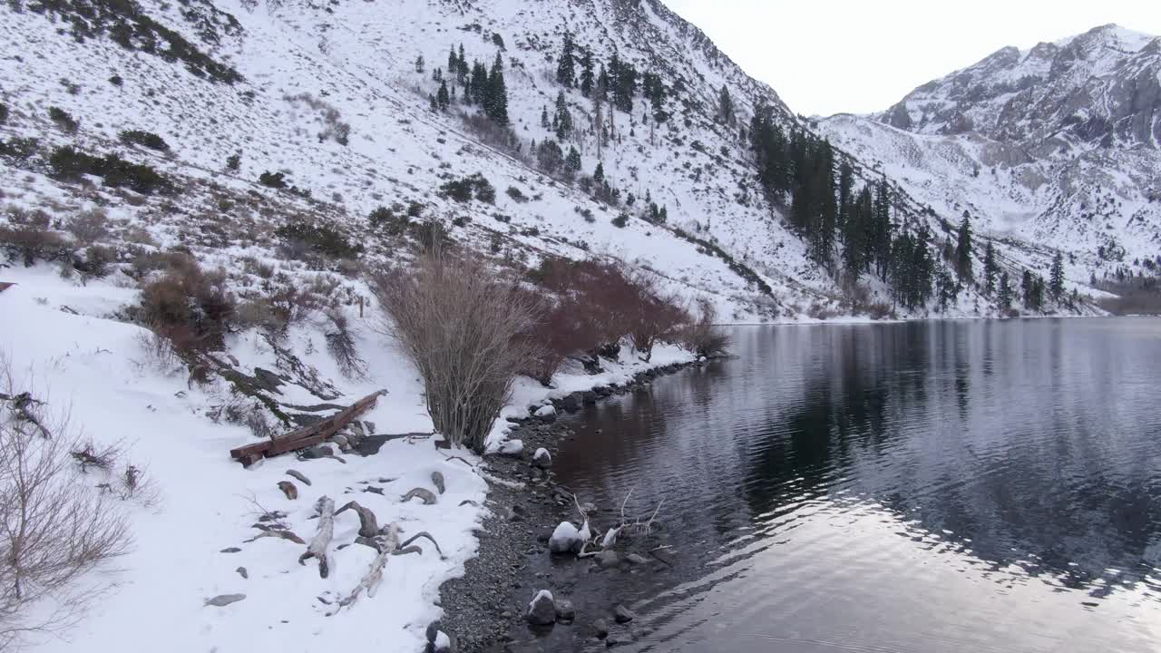 航拍的雪山由定罪湖对天空，无人机在冬天上升的白色景观-猛犸象湖，加利福尼亚视频素材