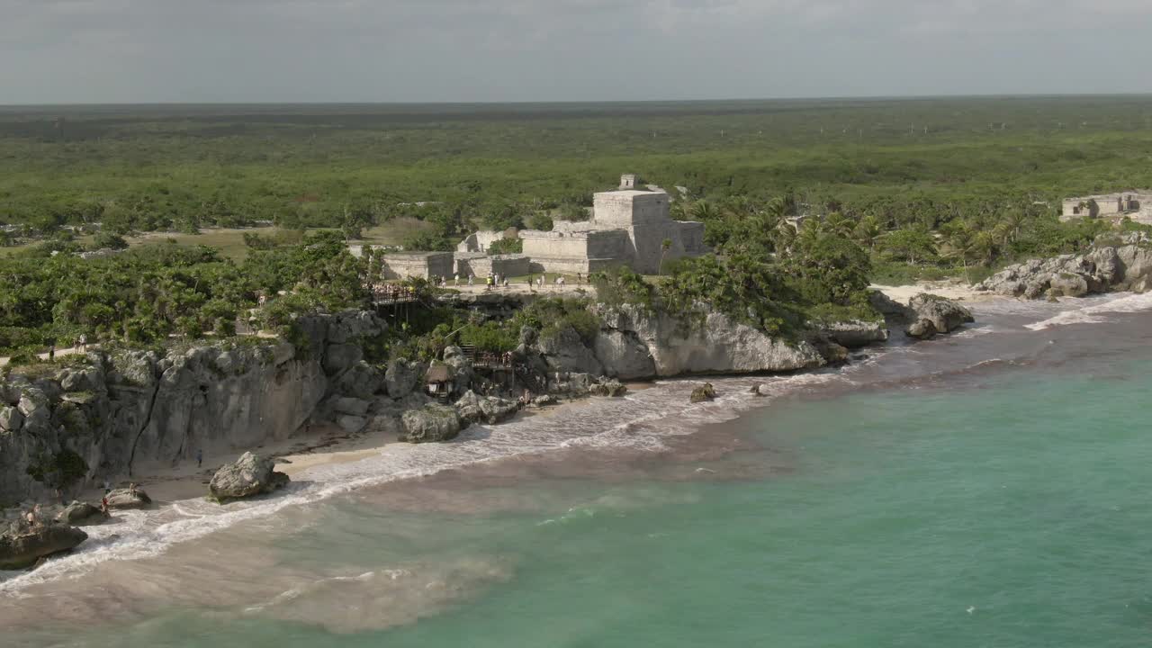 在晴朗的日子里，无人机在游客探索历史地标的上空拍摄著名的图卢姆废墟视频素材