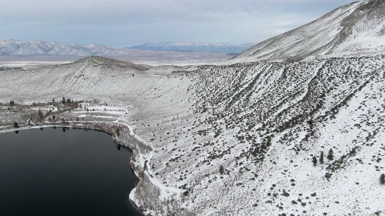 航拍的雪山由定罪湖对天空，无人机在冬季飞行在白色的风景-猛犸湖，加利福尼亚视频素材