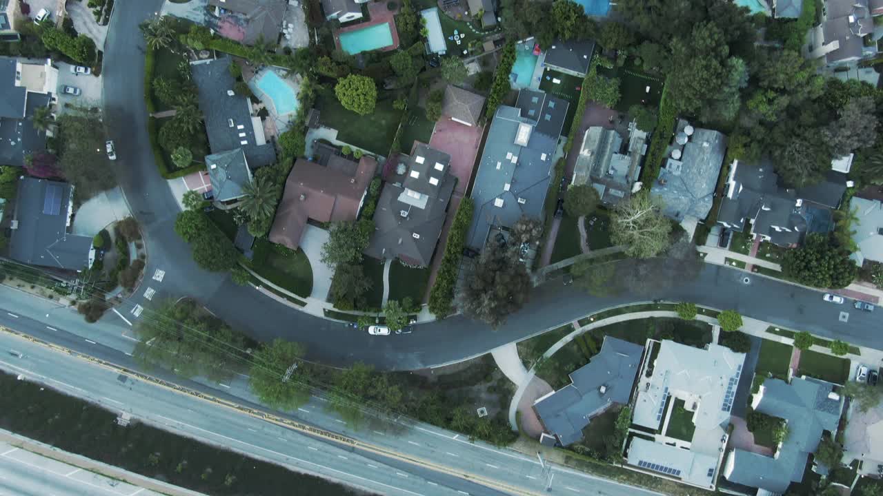 在城市的树木和道路中房屋的空中俯瞰，无人机在日落时飞过住宅区-洛杉矶，加利福尼亚视频素材