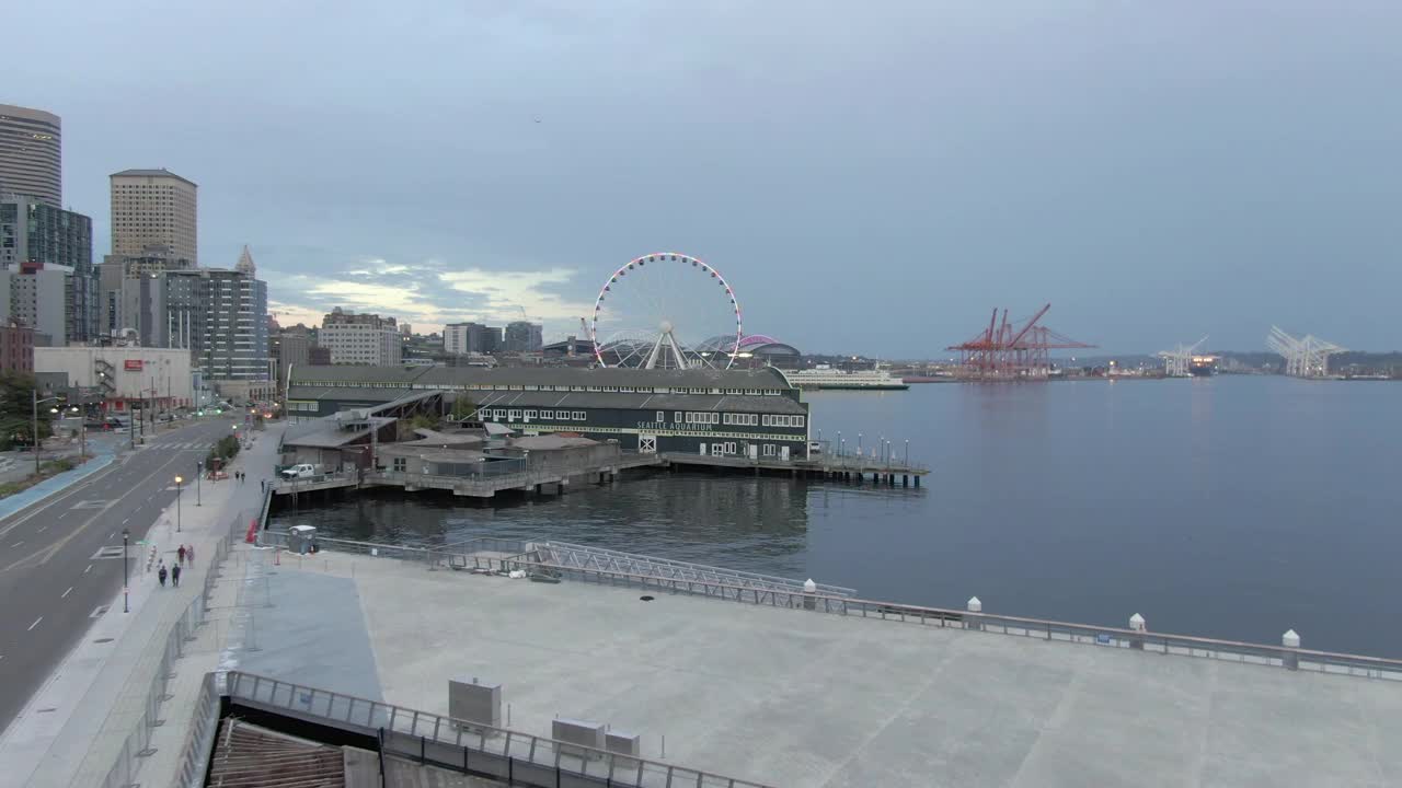 航拍埃利奥特湾码头在城市的天空在黄昏，无人机向前飞向西雅图的伟大车轮视频下载