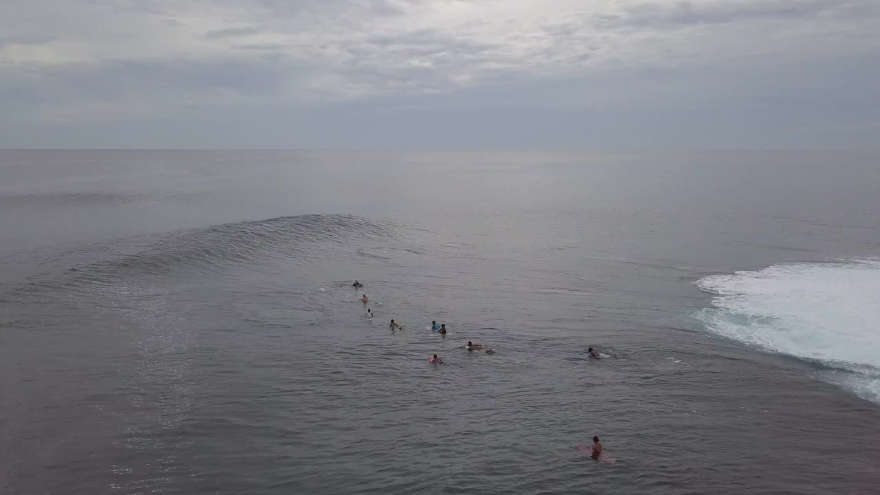 空中平移拍摄的人冲浪在海洋对天空在日落，无人机飞越海洋- Siargao，菲律宾视频下载