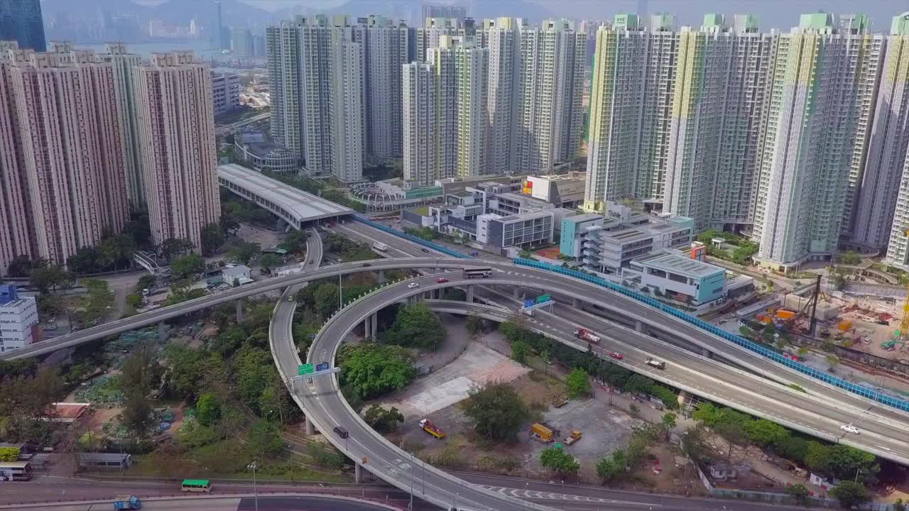 航拍在高楼之间的桥梁上的车辆，无人机飞向城市中的公寓大楼-香港，中国视频素材
