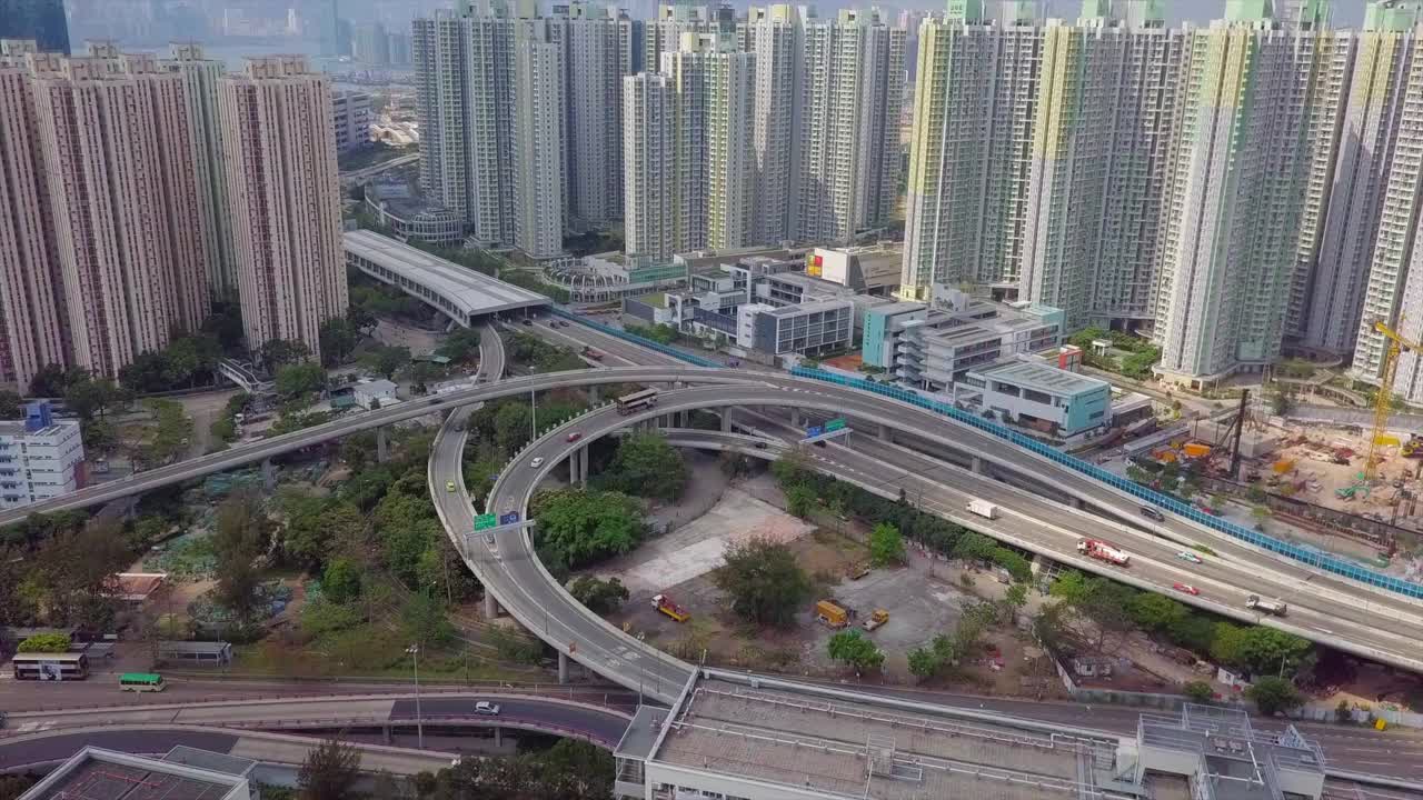 航拍在高楼之间的桥梁上的车辆，无人机飞向城市的住宅建筑-香港，中国视频素材