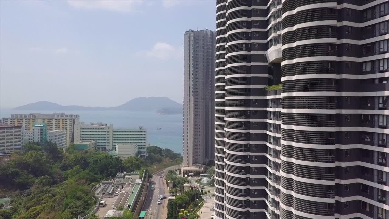 空中拍摄的现代建筑在城市海上对天空，无人机上升的住宅摩天大楼在阳光明媚的日子-香港，中国视频素材