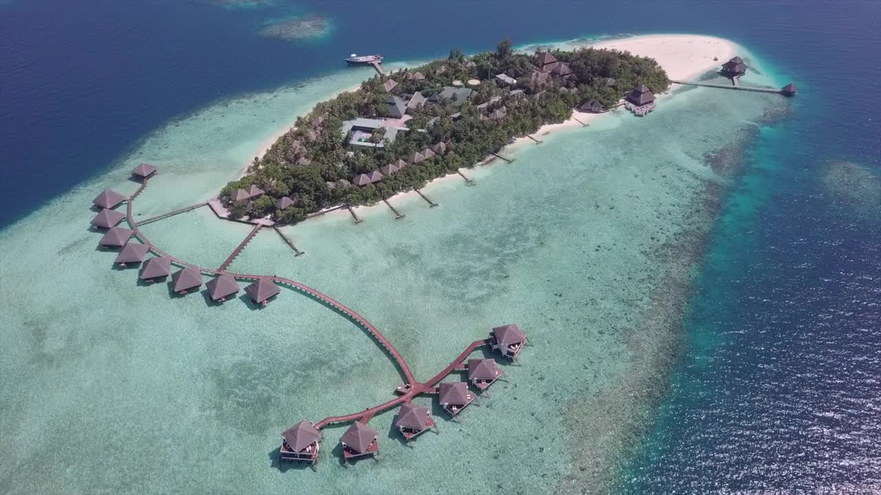 航拍豪华度假岛在海上晴天，无人机向前飞行水上别墅-瓦都，马尔代夫视频下载